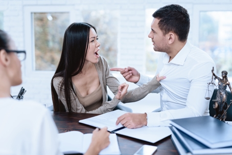 couple fighting in front of a lawyer