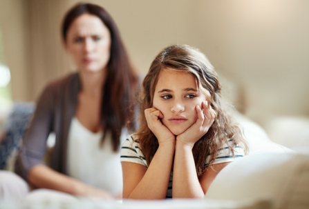 a young girl ignoring angry mother
